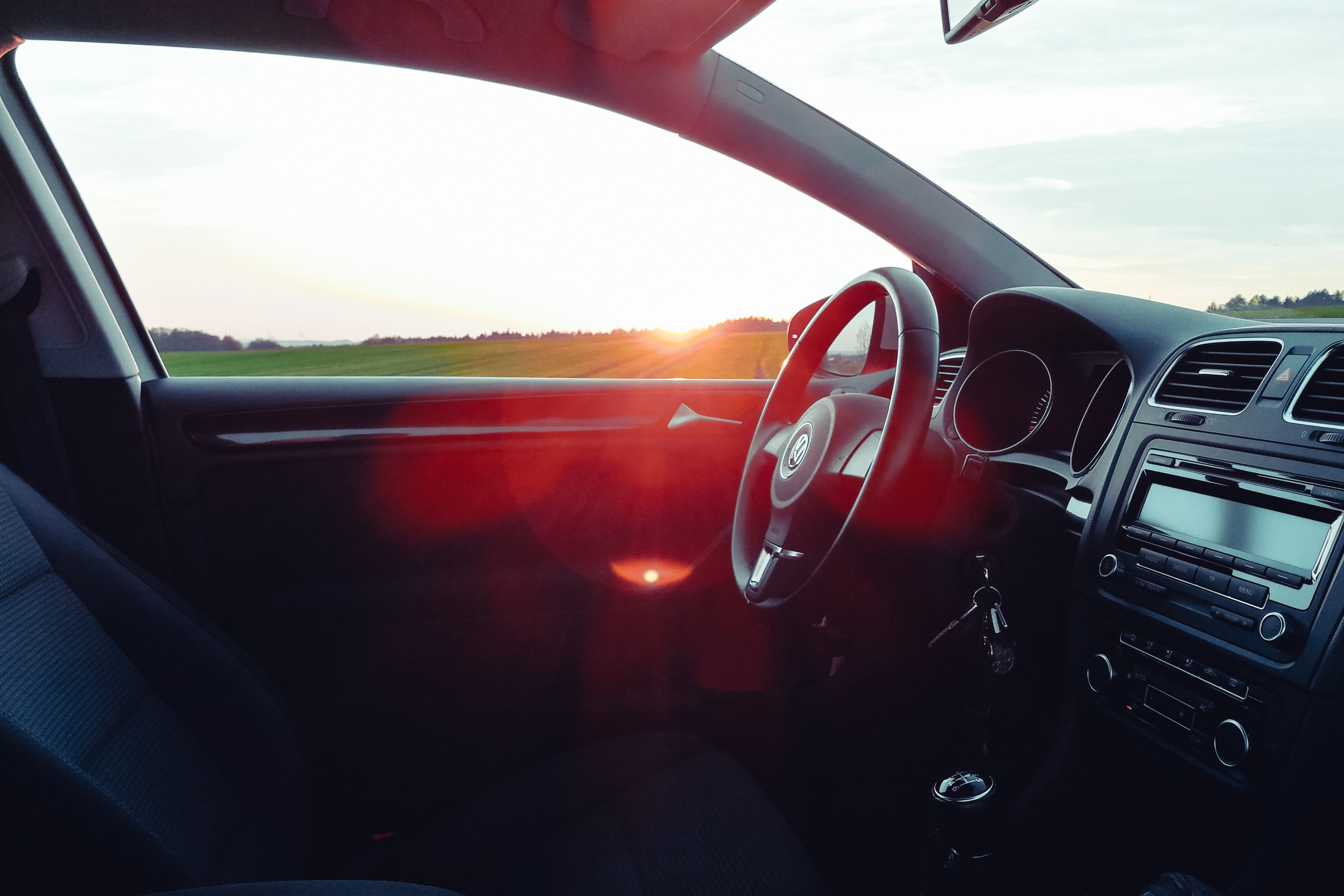 Innenaufnahme eines VW-Autos mit Sonnenuntergang im Hintergrund