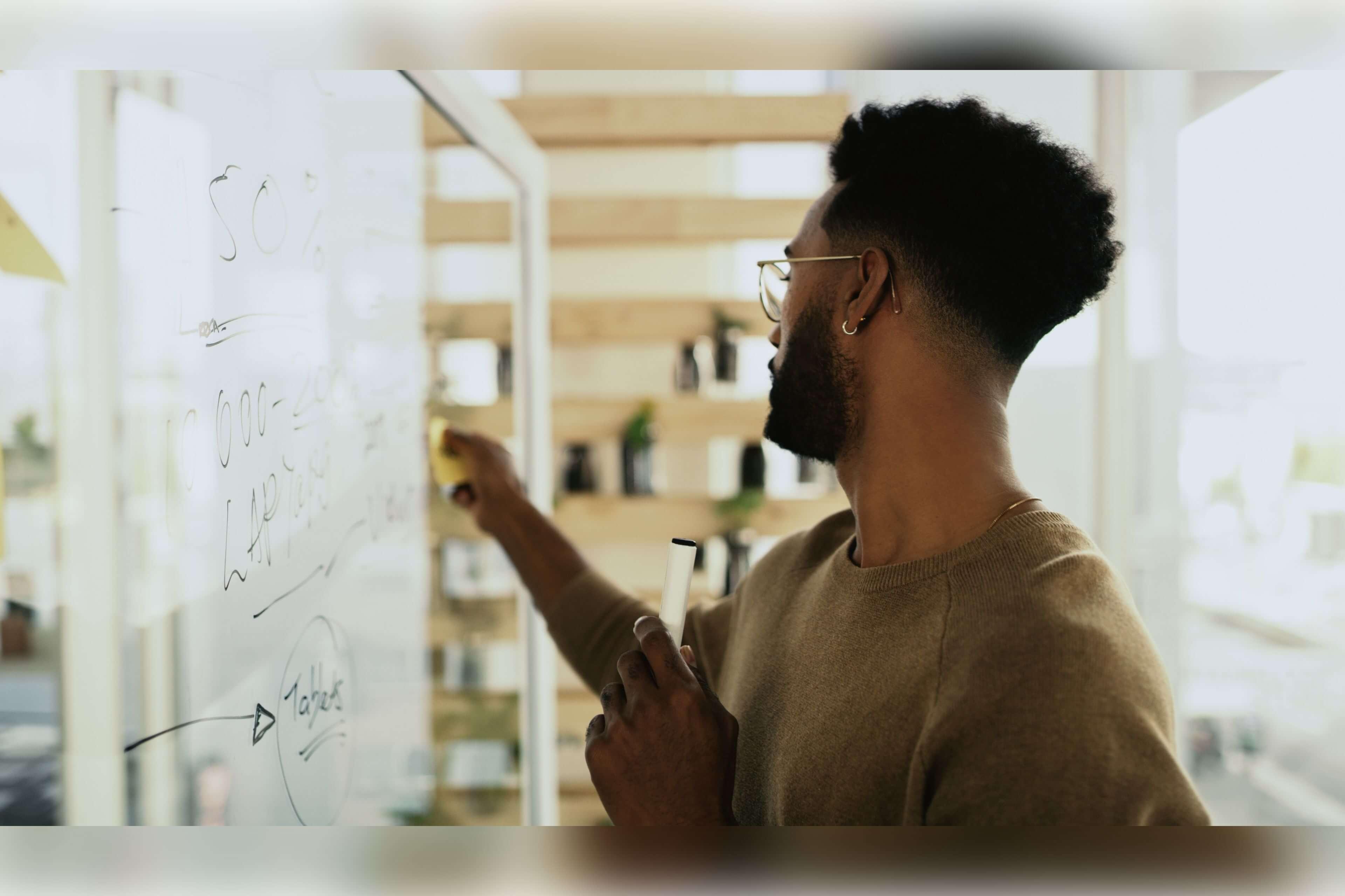 Photo: Man writing on witheboard